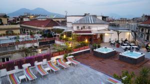 Elle offre une vue sur un toit-terrasse avec des chaises et des tables. dans l'établissement B&B Sweet Sleep, à Naples