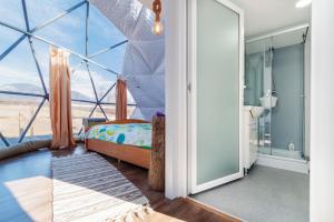 a bedroom with a bed and a large window at Brancoveanu Glamping in Văratici