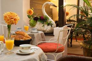 Hôtel du Cygne Paris في باريس: طاولة مع بجعة وطاولة مع خبز وعصير برتقال