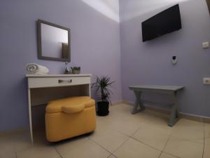 una stanza con tavolo, sgabello e specchio di Karma - 2 bedroom apartment a Città di Zante