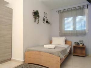 a bedroom with a bed and a window at Karma - 2 bedroom apartment in Zakynthos Town