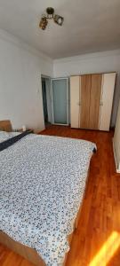 a bedroom with a bed and a wooden floor at Apartament La Denis in Bîrlad