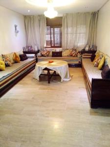 卡薩布蘭卡的住宿－family home，客厅配有沙发和桌子。
