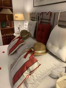 - un lit blanc avec des chapeaux et des oreillers dans l'établissement Chambre et salle de bain cocooning labellisée, à Nice