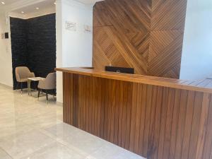 a wooden reception desk in a lobby with chairs at Hotel Residence La Corniche in Dakar