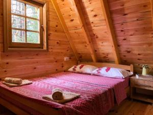 a bedroom with a bed in a log cabin at The Pine Forest Cottage in Žabljak
