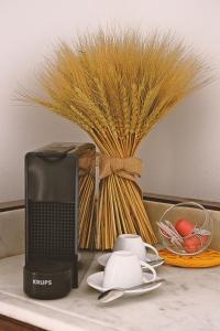 a laptop computer on a table with a vase of wheat at 6/4 de Sado in Setúbal