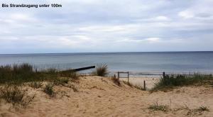 a sandy beach with the ocean in the background at Kleiner Bungalow - Zum Strand 50m in Ueckeritz