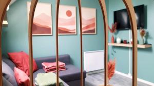 una camera con specchio e divano viola di Stigi, duplex de standing à 100m de la mer a Ouistreham