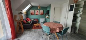 - un salon avec une table et un canapé dans l'établissement Stigi, duplex de standing à 100m de la mer, à Ouistreham