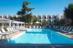 a swimming pool with lounge chairs and a hotel at Novotel Marseille Est Porte d'Aubagne in Marseille