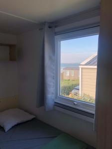 a window in a room with a bed and a windowvisor at La côte sauvage - MH climatisé 2018 - P30 - Le Portel in Le Portel