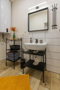 een badkamer met een wastafel en een spiegel bij Sunny Apartment With Free Parking in Zvolen