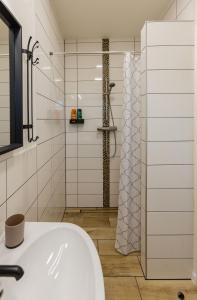 een badkamer met een douche en een witte wastafel bij Sunny Apartment With Free Parking in Zvolen