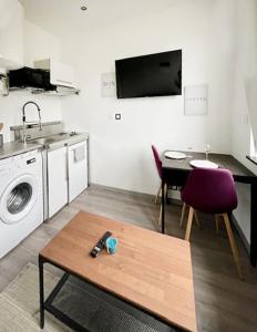 sala de estar con mesa y cocina en Sympathique petit Studio à la frontière du Luxembourg, en Knutange