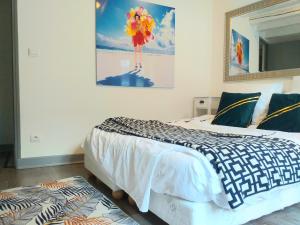 a bedroom with a bed and a painting on the wall at A la Grosse Armée - Dans hôtel particulier, hypercentre avec garage, au calme in Bourges