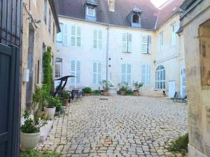 a courtyard of a large white building with plants at A la Grosse Armée - Dans hôtel particulier, hypercentre avec garage, au calme in Bourges