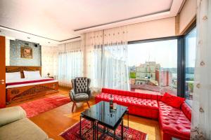 sala de estar con sofá rojo y cama en O'Pera Okanlı Suites en Estambul