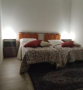 um quarto com 2 camas com almofadas vermelhas em B&B CASETTA 42 em Volpino