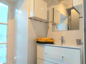 a white bathroom with a sink and a mirror at A la Grosse Armée - Dans hôtel particulier, hypercentre avec garage, au calme in Bourges +6 photos