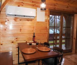 comedor con mesa con sillas y ventilador de techo en The Pine Forest Cottage, en Žabljak