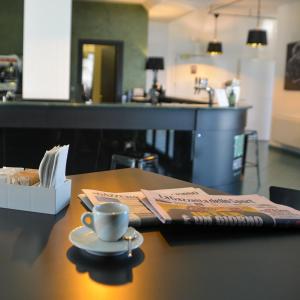 a table with a cup of coffee and a napkin at Tuo Hotel in Polignano a Mare