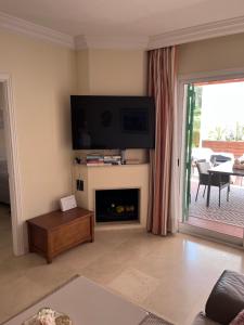 uma sala de estar com lareira e uma televisão de ecrã plano em Estrelicia II em Marbella