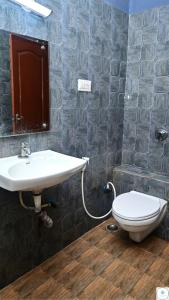 a bathroom with a sink and a toilet at The Roy Grand Inns in Bangalore