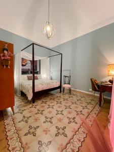 1 dormitorio con cama con dosel y mesa en Wunderkammer Art Gallery Home Catania, en Catania