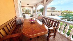 porche con mesa de madera y 2 sillas en Apartments Vukancic en Novigrad Istria