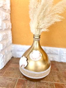 a gold vase with feathers in it on a floor at Apartments Vukancic in Novigrad Istria