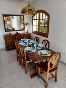 uma mesa de madeira com cadeiras e uma sala de jantar em Chalet a 100m de la playa de Cristal, Pino Alto em Hospitalet de l'Infant