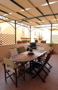 una mesa de madera y sillas en un patio en B&B La Terrazza Sul Porto en Trapani