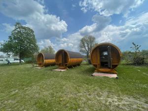 três estruturas circulares de madeira sentadas num campo de relva em Donaucamping Emmersdorf em Emmersdorf an der Donau