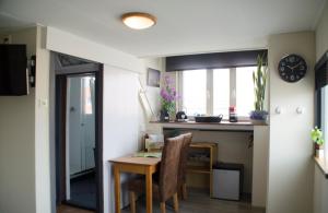 a dining room with a table and a window at 22up Bed & Koffie in Den Burg