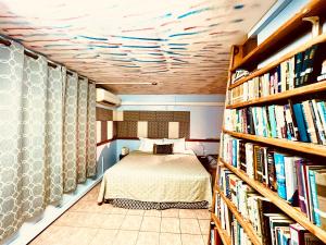 1 dormitorio con cama y estante para libros en Cool Premier Apts. - Airport/SGU, en Blow Hole