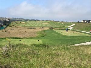 a man is standing on a green golf course at Oubaai Golf Estate in George