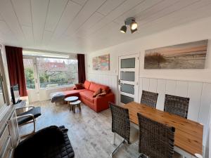 ein Wohnzimmer mit einem roten Sofa und Stühlen in der Unterkunft Vakantiehuisje Martina 26 in Vlissingen