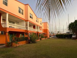 un edificio con una palmera delante de él en Cool Premier Apts. - Airport/SGU, en Blow Hole