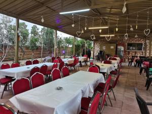 a restaurant with white tables and red chairs at Madaba Camp Resort in Madaba
