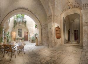 een boog in een gebouw met een tafel en stoelen bij FORLEO Historic Apartments - TREB Collection in Lecce