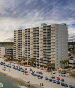 a large building on a beach with umbrellas at 0209 Waters Edge Resort condo in Myrtle Beach