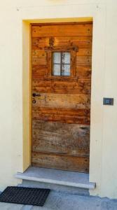 een houten deur met een raam in een huis bij Accogliente e confortevole appartamento a Doues in Doues
