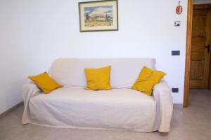 een witte bank met gele kussens erop bij Accogliente e confortevole appartamento a Doues in Doues