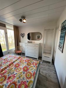 ein Schlafzimmer mit einem Bett, einer Kommode und einem TV in der Unterkunft Vakantiehuisje Martina 26 in Vlissingen