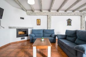 Sala de estar con sofás azules y mesa de centro en Casa Playamar en Vejer de la Frontera