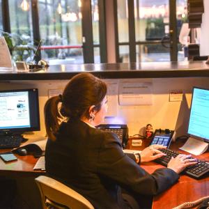 a woman sitting at a desk working on a computer at Tuo Hotel in Polignano a Mare