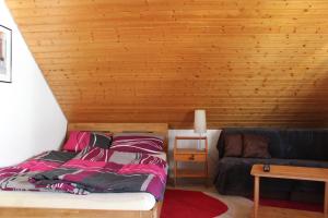 a bed in a room with a wooden wall at Ferienwohnung auf 1233m am Feldberg nur 20m zur Skilift/-piste, Wanderwegen und Bus in Feldberg
