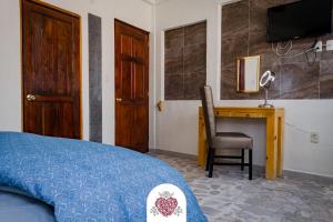 a bedroom with a bed and a desk and a television at Hotel Corazón de Plata Centro in Guanajuato +54 photos