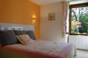 1 dormitorio con 1 cama y ventana en Gîte 295 Montagnes du Jura avec Spa et Sauna classé 3 étoiles en Foncine-le-Haut